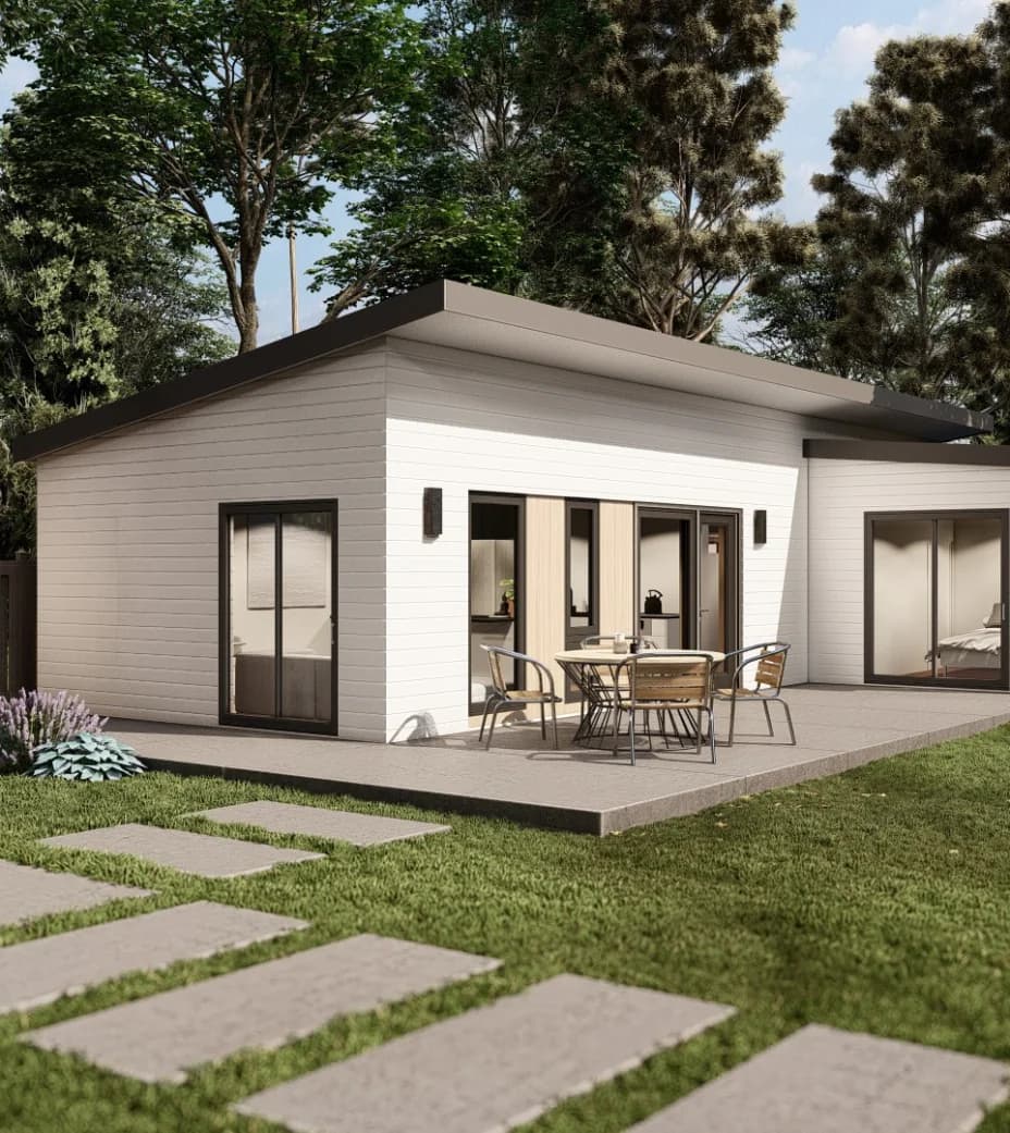 White single-story backyard ADU with a covered patio and a stepping-stone path across the lawn