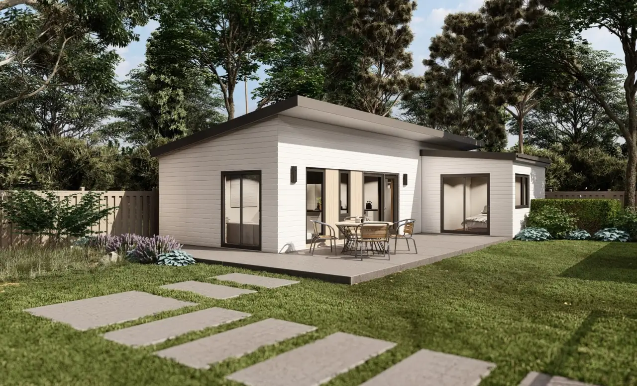 White single-story backyard ADU with a covered patio and a stepping-stone path across the lawn